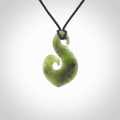 This koru/matau, is carved from a very striking New Zealand jade. It is both intricate and simple in design - it has hidden folds and smooth curves. A piece to be worn, the carving and the jade are both magnificent.