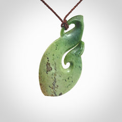 This matau, is a large pendant hand carved from New Zealand jade. It is both intricate and contemporary in design - it has hidden folds and smooth curves. A piece to be worn, the carving and the jade are both magnificent. A large hand carved New Zealand Jade hook by artist Ric Moor.