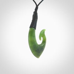 This picture shows a jade hook pendant, also called a hei-matau, carved for us in New Zealand jade. The carver is Ric Moor - and this is a beautiful example of his work. The cord is a four-plait, adjustable black coloured necklace.