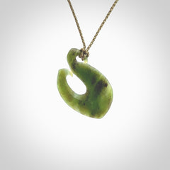 This picture shows a jade hook pendant, also called a hei-matau, carved for us in New Zealand jade. The carver is Ric Moor - and this is a beautiful example of his work. The cord is a four-plait, adjustable khaki coloured necklace.