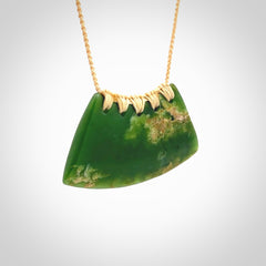 This picture shows a hand carved jade contemporary half-shield pendant. It is a deep green colour with orange and lighter shades of green throughout. This is a wonderful piece of jewellery. The cord is hand plaited and adjustable so that you can position the pendant where it suits you best. This piece was carved for us by Ric Moor. Delivery is free worldwide.