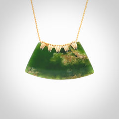 This picture shows a hand carved jade contemporary half-shield pendant. It is a deep green colour with orange and lighter shades of green throughout. This is a wonderful piece of jewellery. The cord is hand plaited and adjustable so that you can position the pendant where it suits you best. This piece was carved for us by Ric Moor. Delivery is free worldwide.