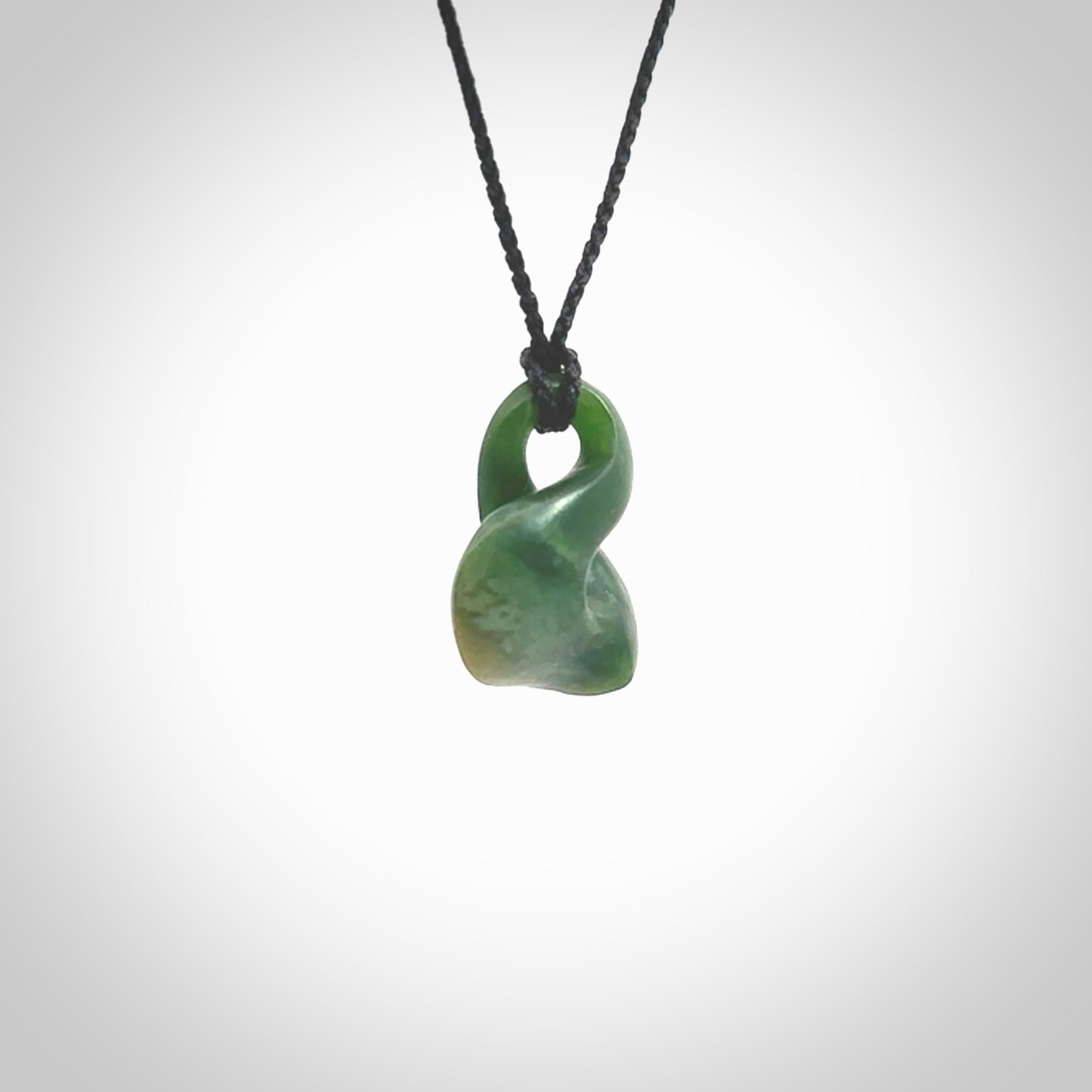 This piece is a fine, delicate drop shaped, single twist pendant. It was carved for us by Ric Moor from a lovely deep green piece of New Zealand jade. It is suspended on an black four plaited braided cord that is length adjustable.