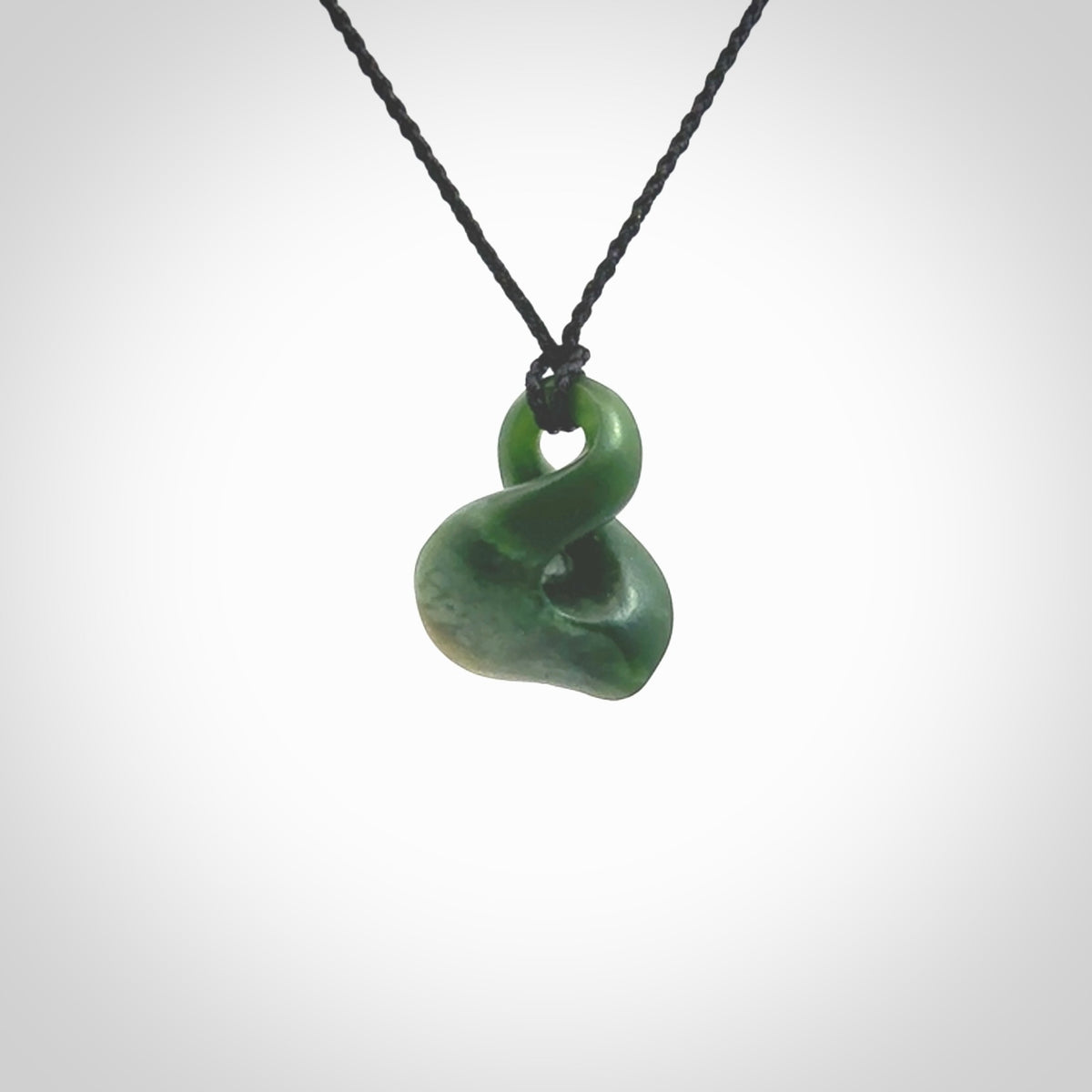 This piece is a fine, delicate drop shaped, single twist pendant. It was carved for us by Ric Moor from a lovely deep green piece of New Zealand jade. It is suspended on an black four plaited braided cord that is length adjustable.