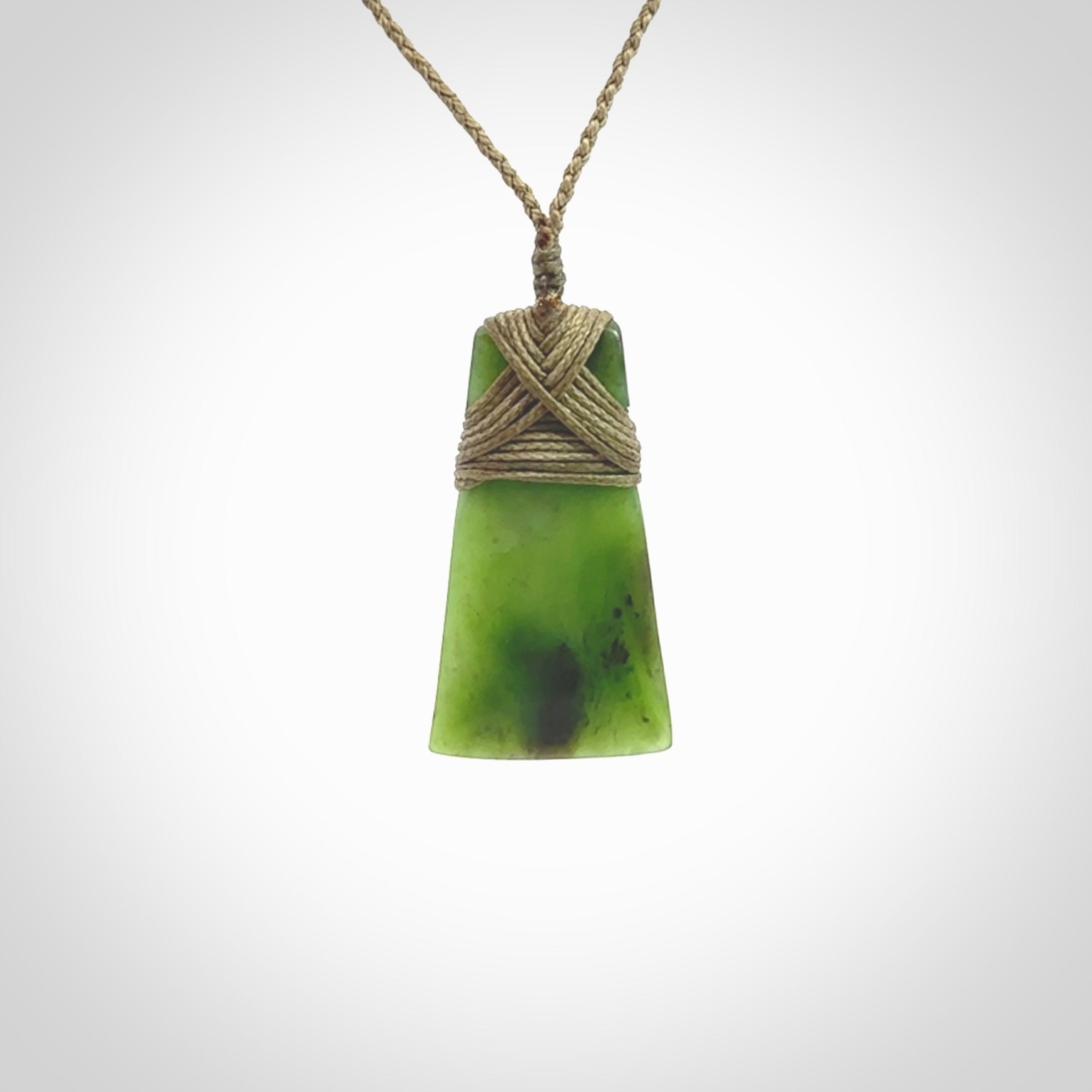 Toki pendant hand carved from a lovely piece of local New Zealand Jade. The quality of the workmanship and design is outstanding - this is a piece you will want to wear all the time. We have suspended this from a 3-plait khaki cord which can be adjusted with a couple of slip knots and beige binding.