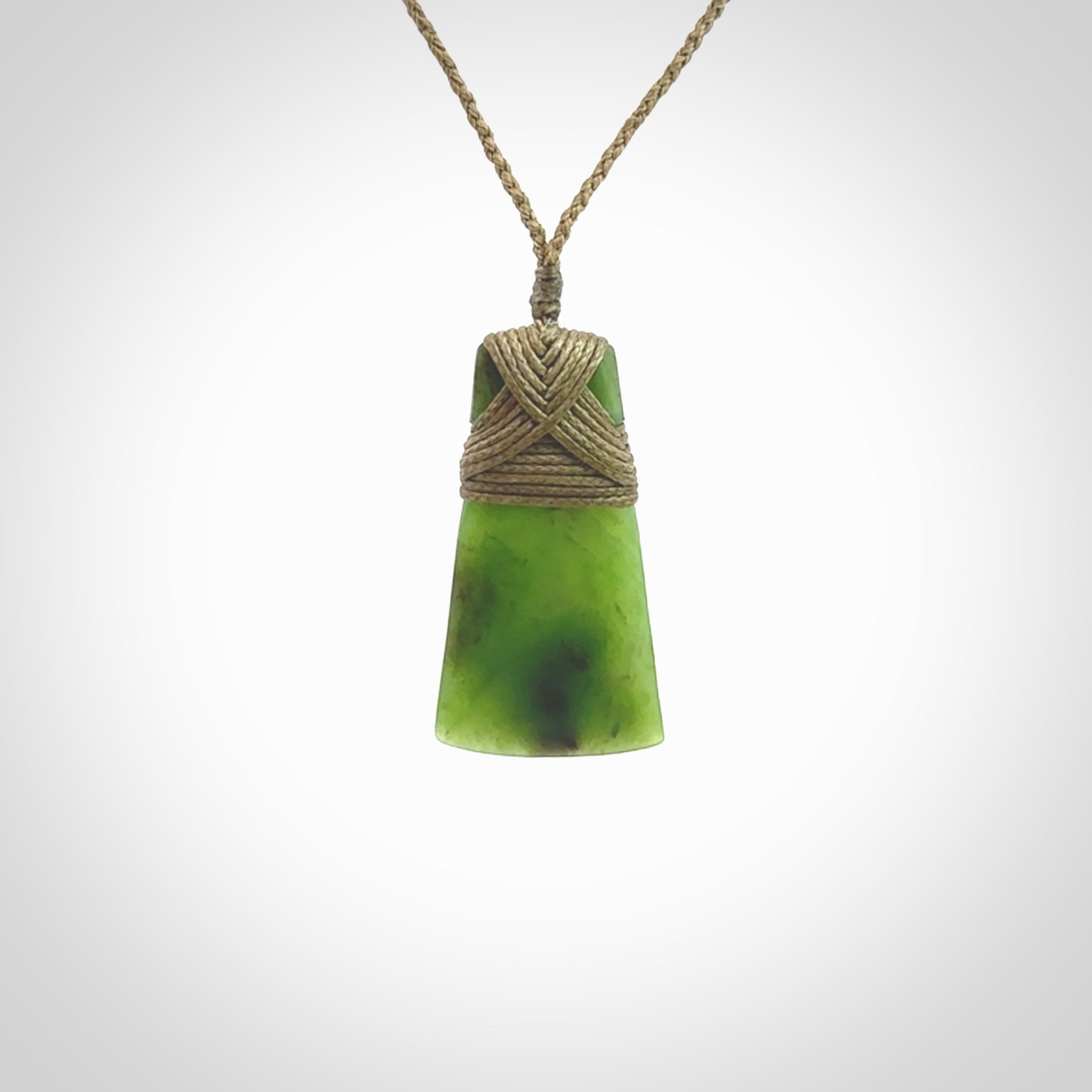 Toki pendant hand carved from a lovely piece of local New Zealand Jade. The quality of the workmanship and design is outstanding - this is a piece you will want to wear all the time. We have suspended this from a 3-plait khaki cord which can be adjusted with a couple of slip knots and beige binding.