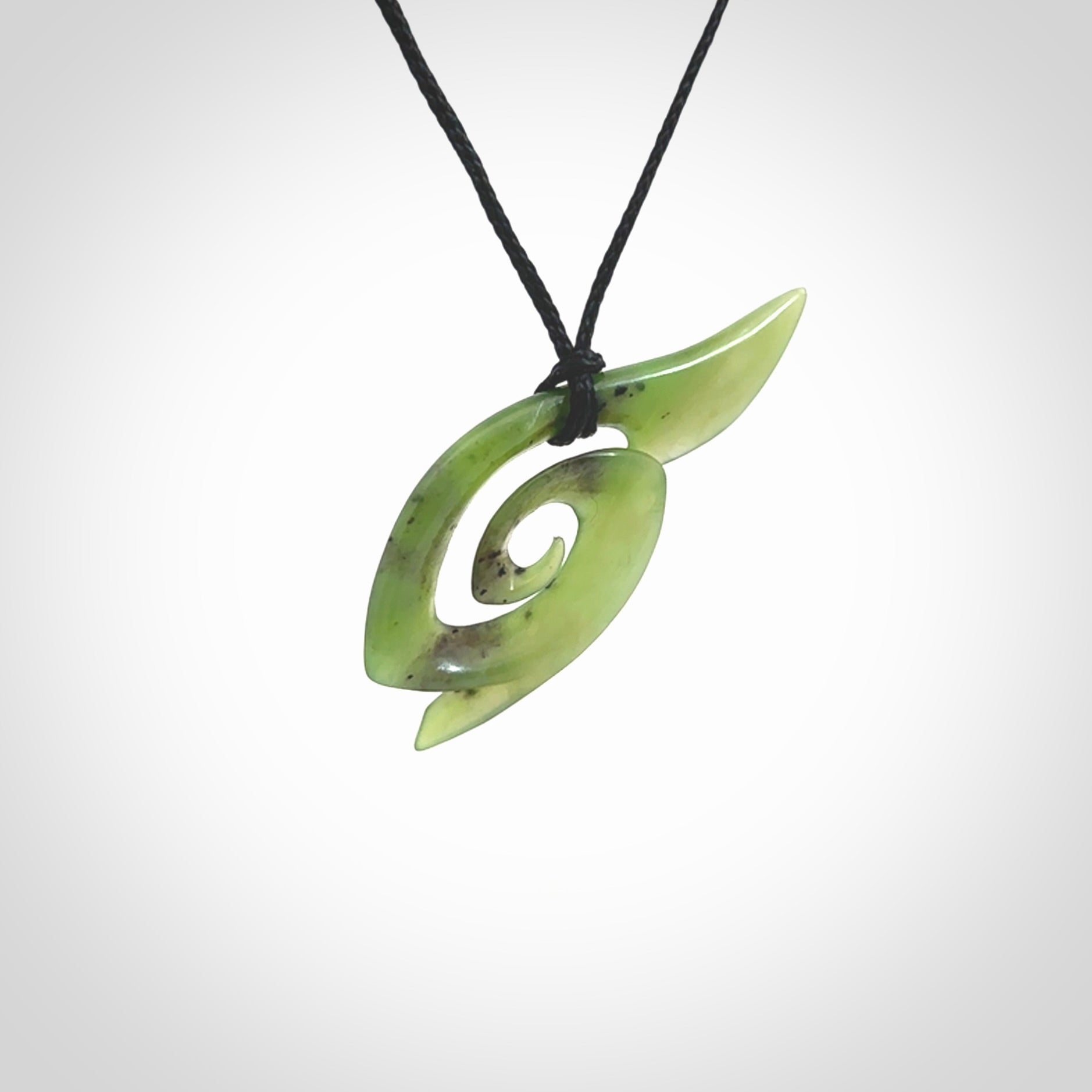 This photo shows a koru pendant carved from New Zealand Jade. The artist, Shaun Gardiner, has carved this beautifully. We provide this piece with an adjustable black cord. This is a fantastic work of art, we have one only.