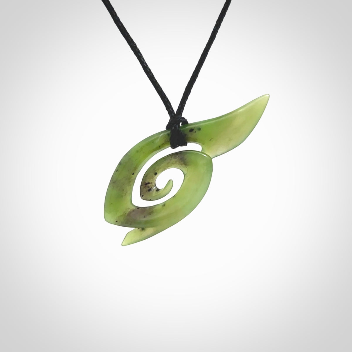 This photo shows a koru pendant carved from New Zealand Jade. The artist, Shaun Gardiner, has carved this beautifully. We provide this piece with an adjustable black cord. This is a fantastic work of art, we have one only.