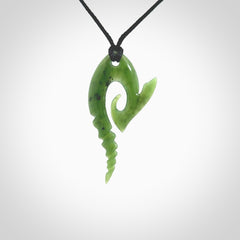 This photo shows a contemporary koru with whale tail pendant carved from New Zealand Jade. The artist, Shaun Gardiner, has carved this beautifully. We provide this piece with an adjustable Black cord. This is a fantastic work of art, we have one only.