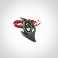 This photo shows a koru pendant carved from New Zealand Jade. The artist, Shaun Gardiner, has carved this beautifully. We provide this piece with an adjustable red cord. This is a fantastic work of art, we have one only.