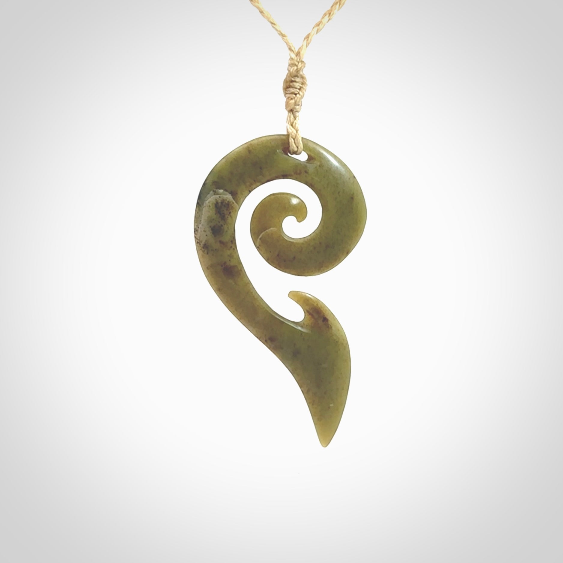 This photo shows a koru pendant carved from New Zealand Jade. The artist, Shaun Gardiner, has carved this beautifully. We provide this piece with an adjustable oat cord. This is a fantastic work of art, we have one only.