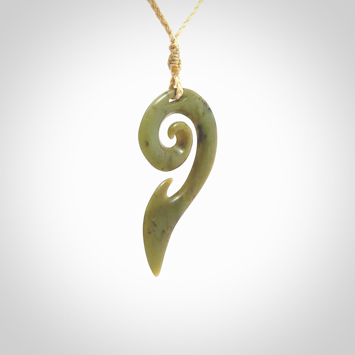 This photo shows a koru pendant carved from New Zealand Jade. The artist, Shaun Gardiner, has carved this beautifully. We provide this piece with an adjustable oat cord. This is a fantastic work of art, we have one only.