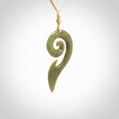 This photo shows a koru pendant carved from New Zealand Jade. The artist, Shaun Gardiner, has carved this beautifully. We provide this piece with an adjustable oat cord. This is a fantastic work of art, we have one only.