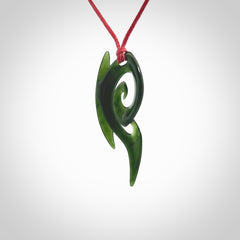 This photo shows a koru pendant carved from New Zealand Jade. The artist, Shaun Gardiner, has carved this beautifully. We provide this piece with an adjustable red cord. This is a fantastic work of art, we have one only.