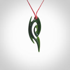 This photo shows a koru pendant carved from New Zealand Jade. The artist, Shaun Gardiner, has carved this beautifully. We provide this piece with an adjustable red cord. This is a fantastic work of art, we have one only.