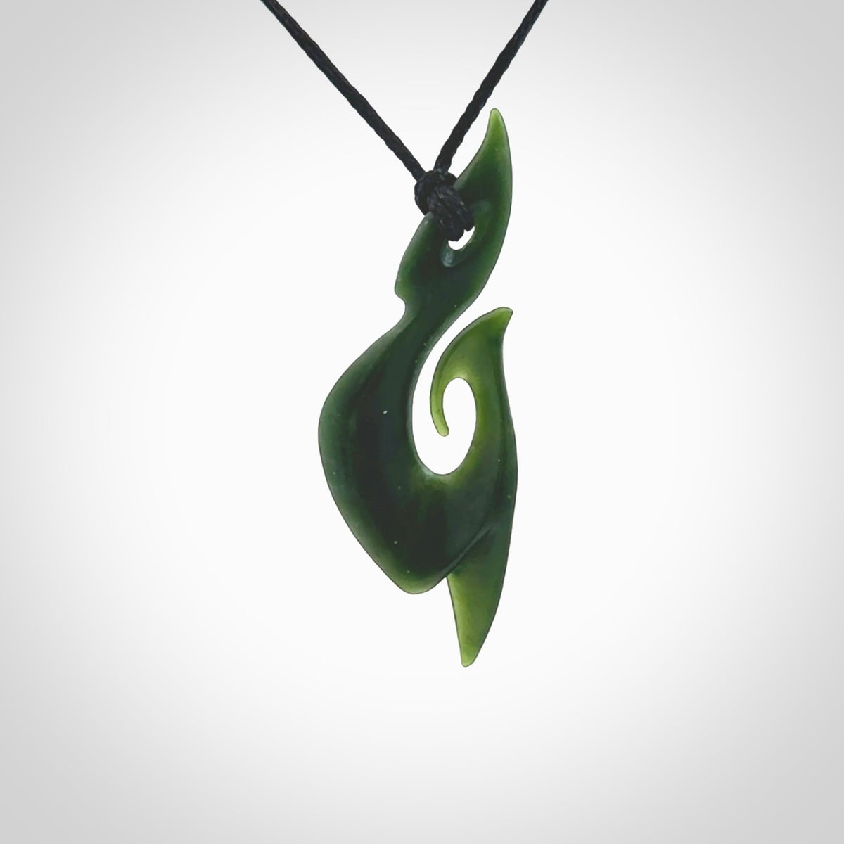 This photo shows a large hook with koru pendant carved from New Zealand Jade. The artist, Shaun Gardiner, has carved this beautifully. We provide this piece with an adjustable black cord. This is a fantastic work of art, we have one only.