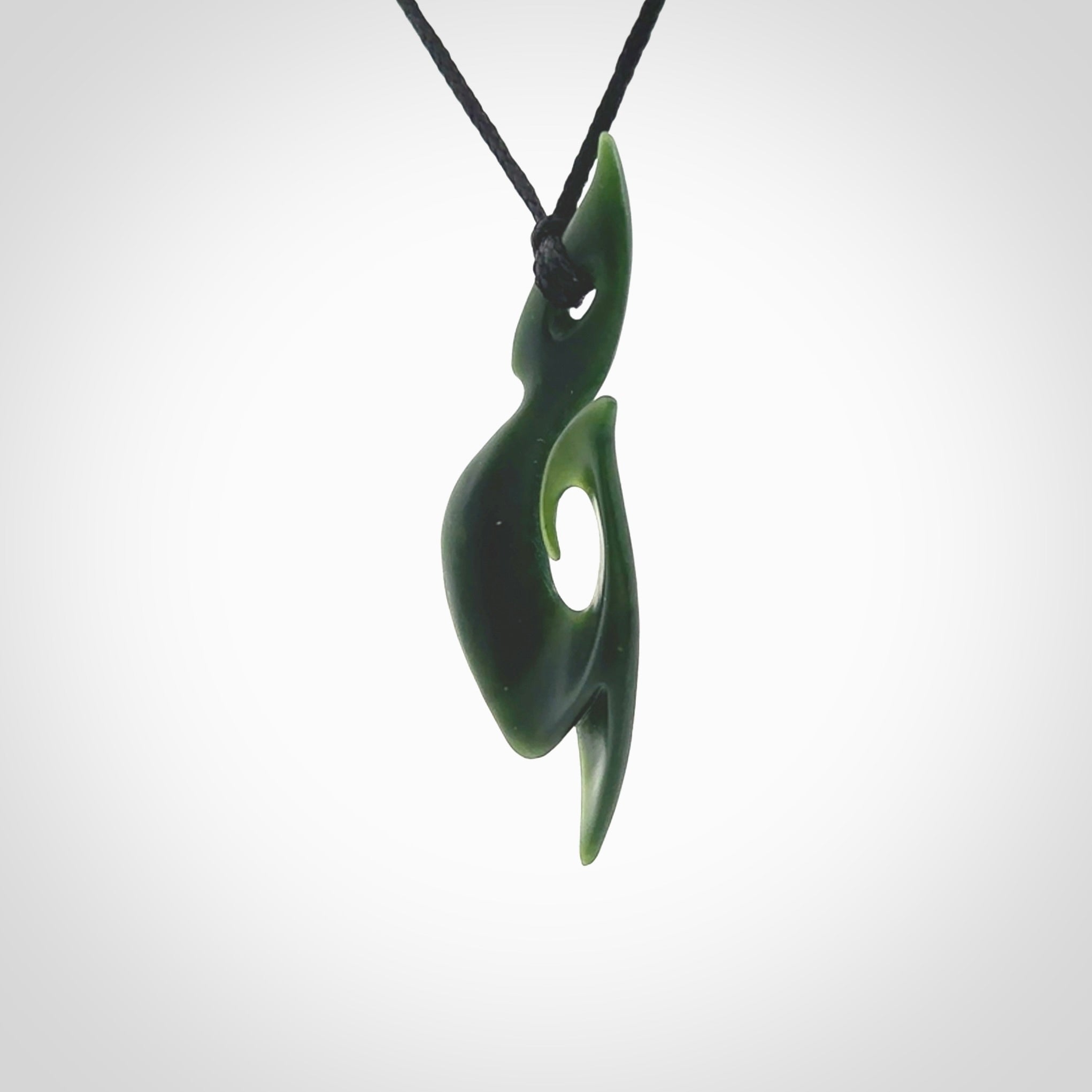 This photo shows a large hook with koru pendant carved from New Zealand Jade. The artist, Shaun Gardiner, has carved this beautifully. We provide this piece with an adjustable black cord. This is a fantastic work of art, we have one only.