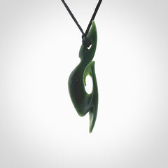 This photo shows a large hook with koru pendant carved from New Zealand Jade. The artist, Shaun Gardiner, has carved this beautifully. We provide this piece with an adjustable black cord. This is a fantastic work of art, we have one only.