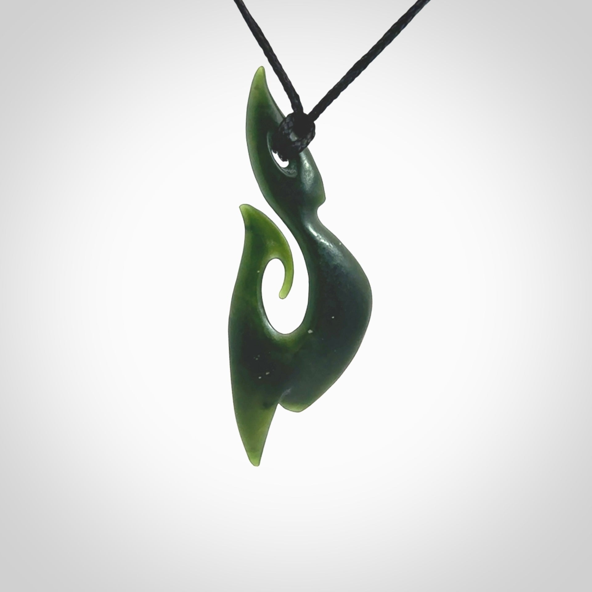 This photo shows a large hook with koru pendant carved from New Zealand Jade. The artist, Shaun Gardiner, has carved this beautifully. We provide this piece with an adjustable black cord. This is a fantastic work of art, we have one only.