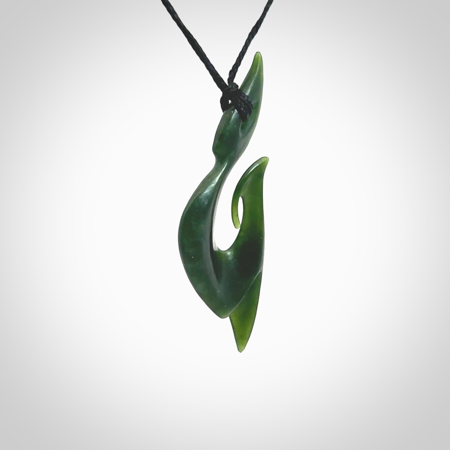 This photo shows a large hook with koru pendant carved from New Zealand Jade. The artist, Shaun Gardiner, has carved this beautifully. We provide this piece with an adjustable black cord. This is a fantastic work of art, we have one only.