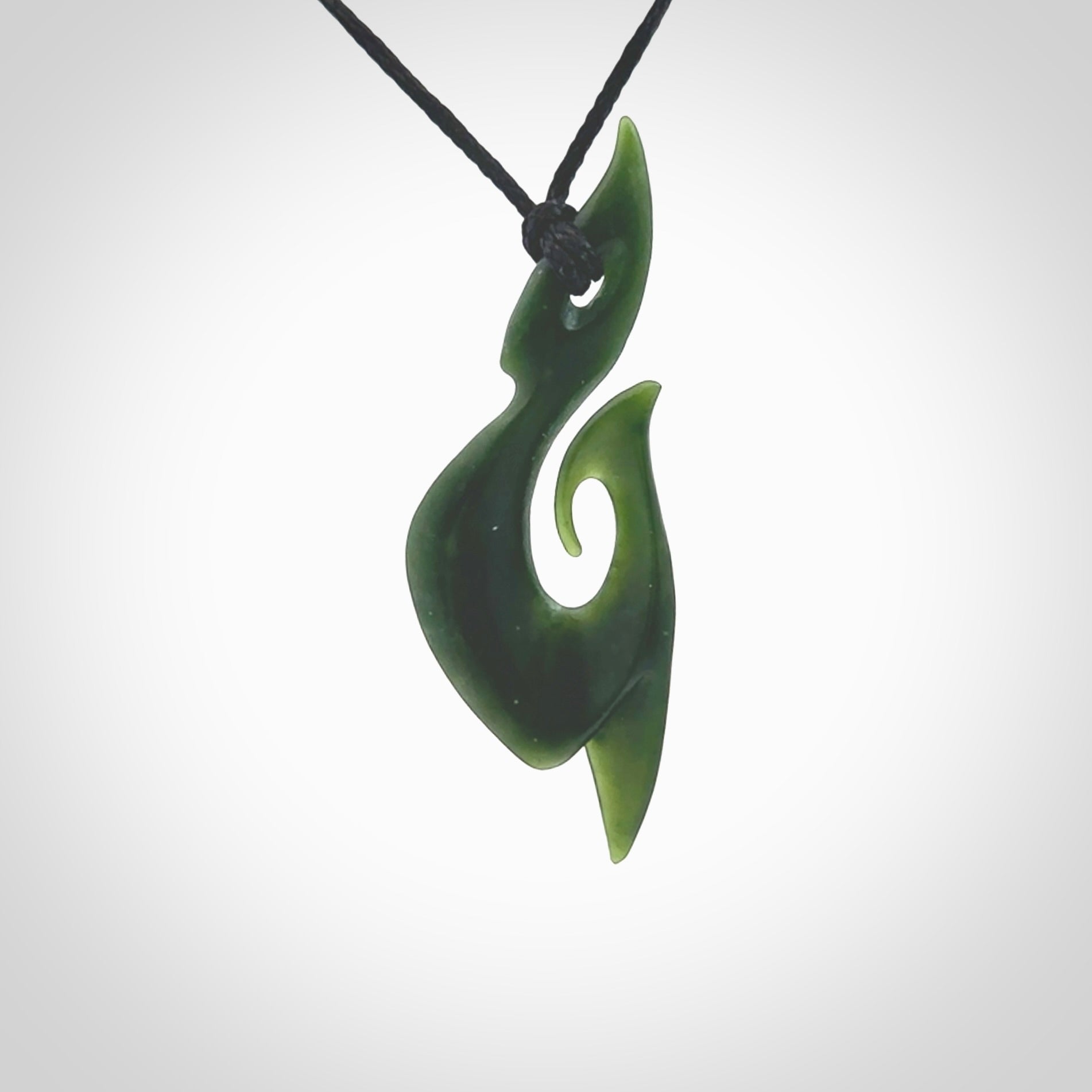 This photo shows a large hook with koru pendant carved from New Zealand Jade. The artist, Shaun Gardiner, has carved this beautifully. We provide this piece with an adjustable black cord. This is a fantastic work of art, we have one only.