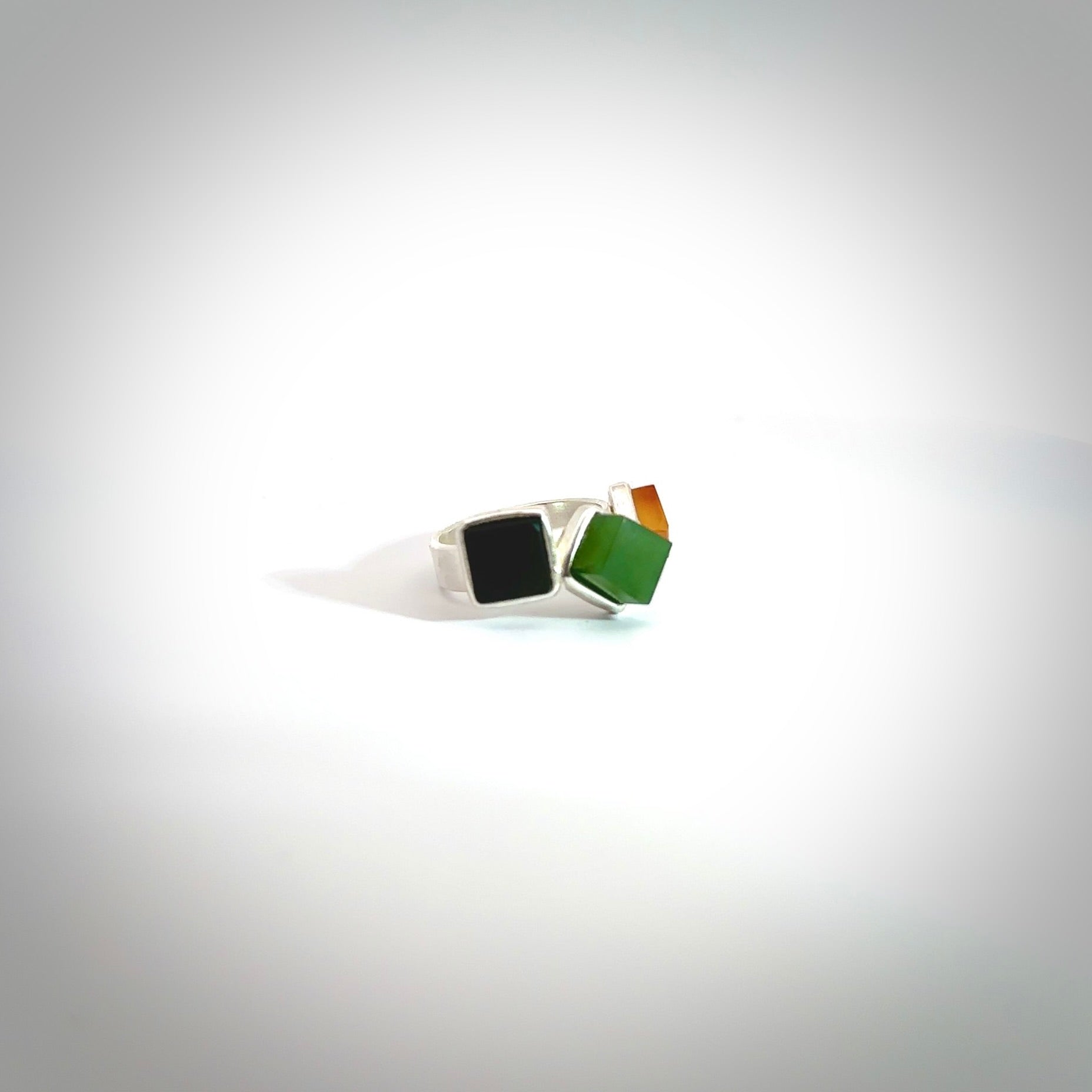 This is a handcrafted New Zealand Pounamu, Jade with Chalcedony and sterling silver ring. This is a solid little work of art. We ship this worldwide for free and are happy to answer any questions that you may have about these or other products on our website. Delivered with Express Courier in a woven kete pouch.