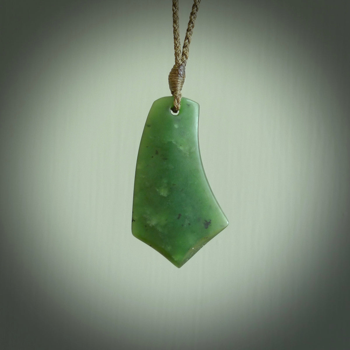 This picture shows a medium sized hand carved jade drop pendant by Ric Moor. The jade is a wonderful deep green. It is suspended from a khaki adjustable cord. Delivery is free worldwide.