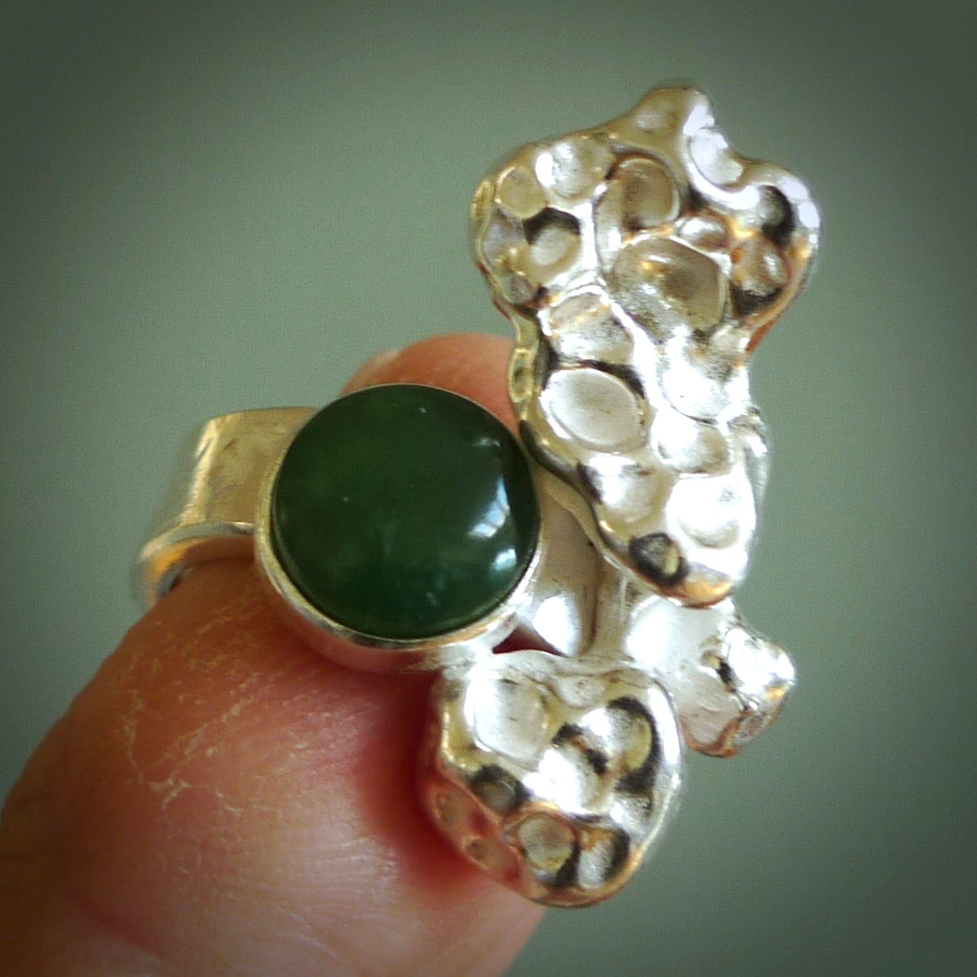 This is a handcrafted New Zealand Pounamu, Jade and sterling silver ring. This is a solid little work of art. We ship this worldwide for free and are happy to answer any questions that you may have about these or other products on our website.