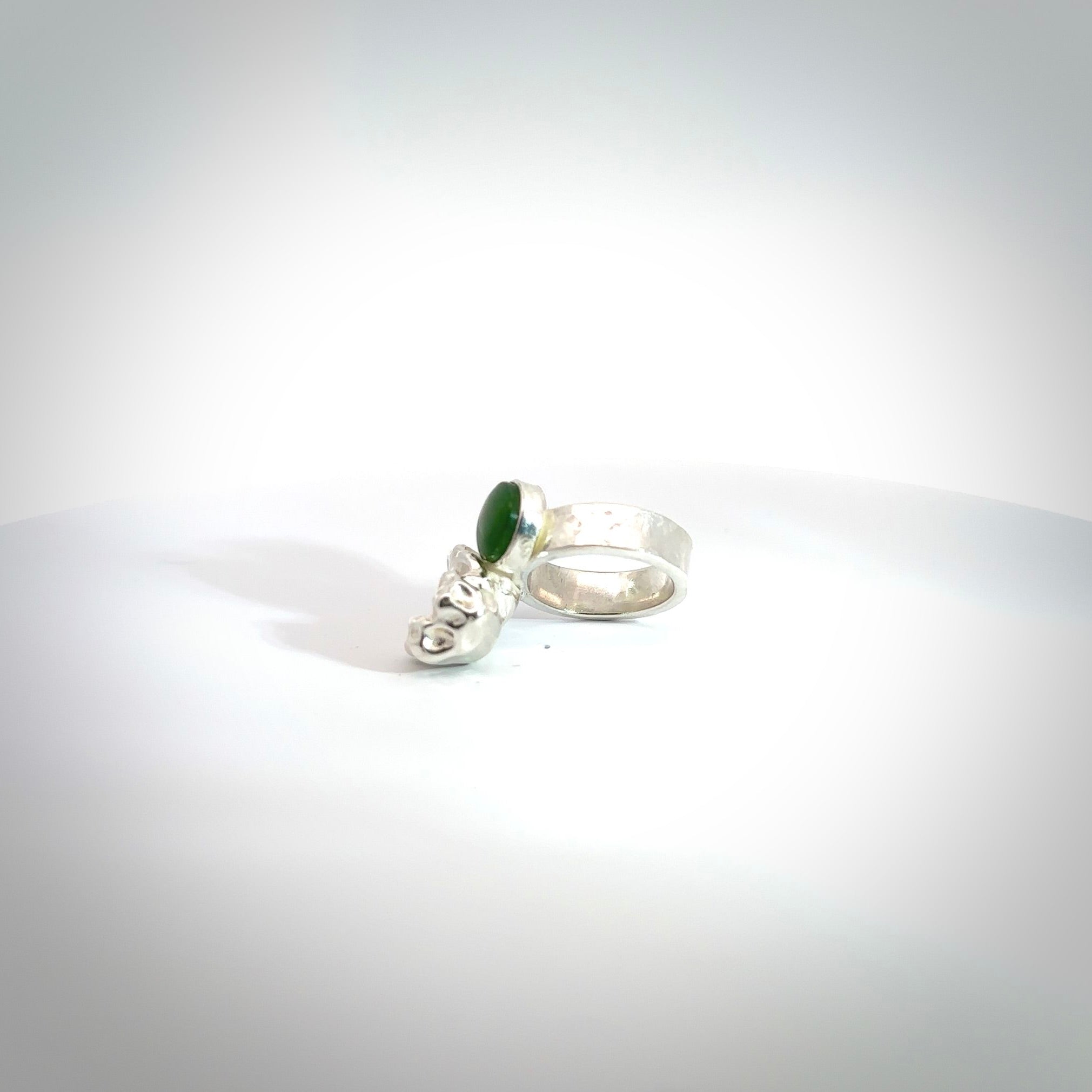 This is a handcrafted New Zealand Pounamu, Jade and sterling silver ring. This is a solid little work of art. We ship this worldwide for free and are happy to answer any questions that you may have about these or other products on our website.