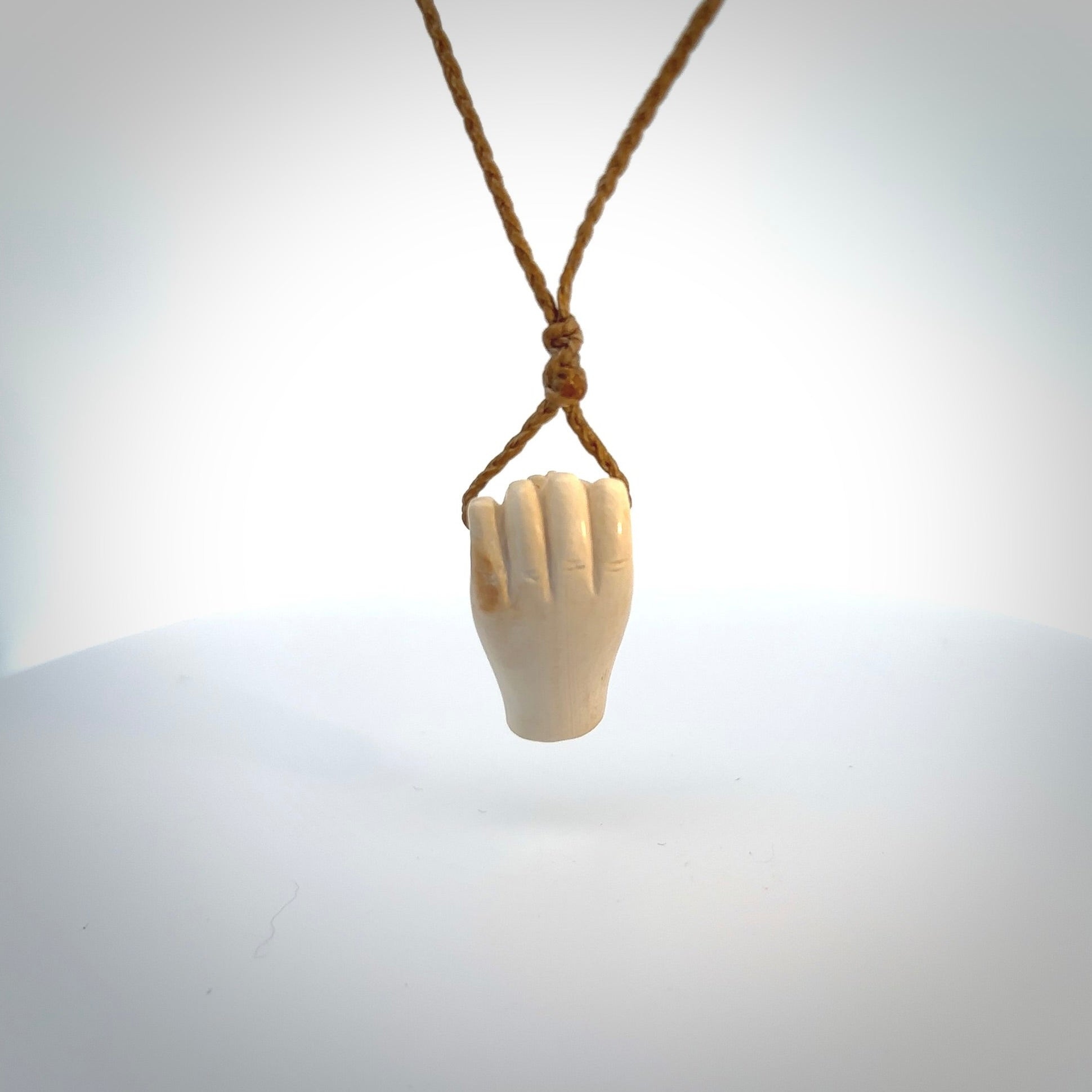 Hand carved pendant symbolising strength and hope - Shown worn. Carved by NZ Pacific from ancient woolly mammoth tusk. Unique jewellery for sale online.