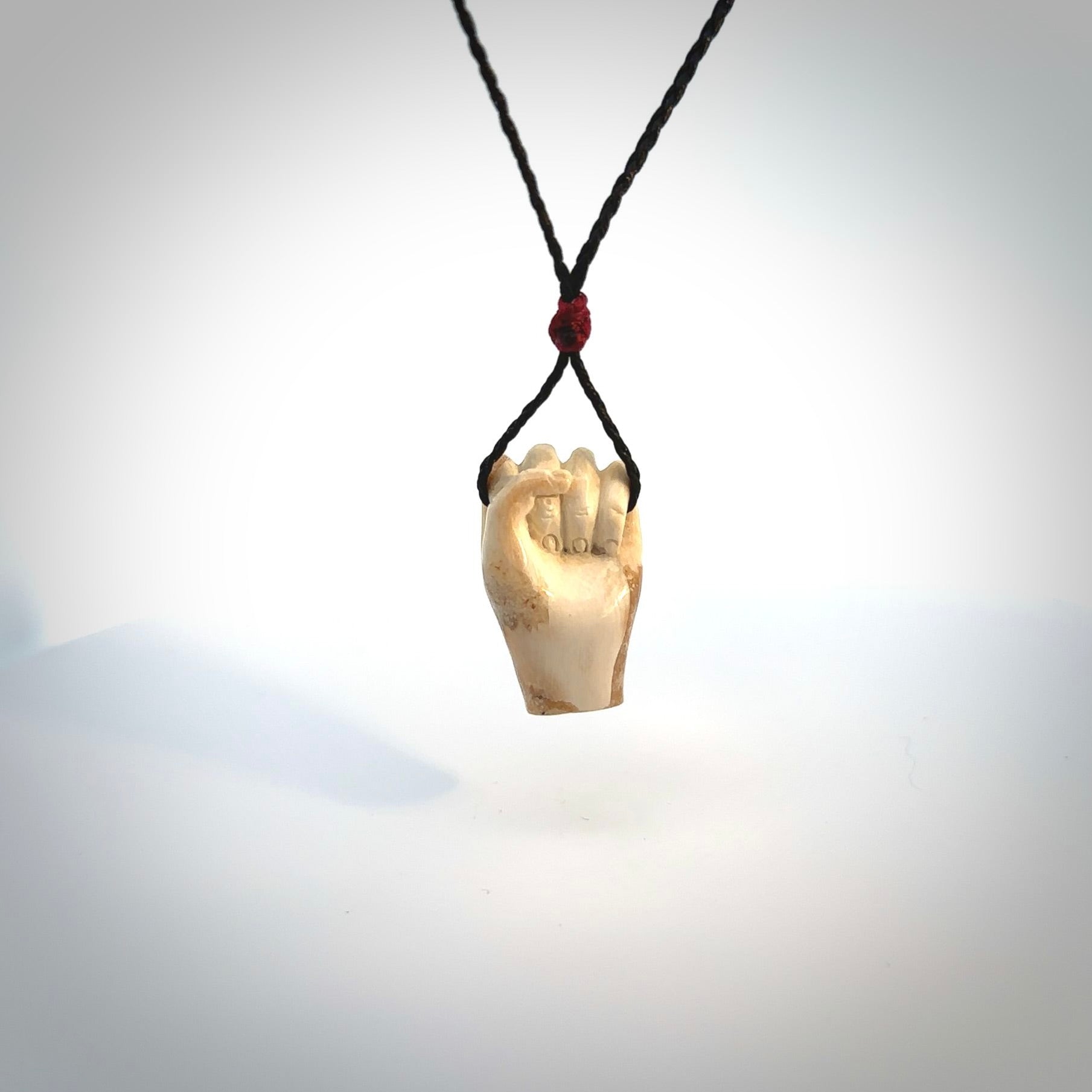 Hand carved pendant symbolising strength and hope - Shown worn. Carved by NZ Pacific from ancient woolly mammoth tusk. Unique jewellery for sale online.