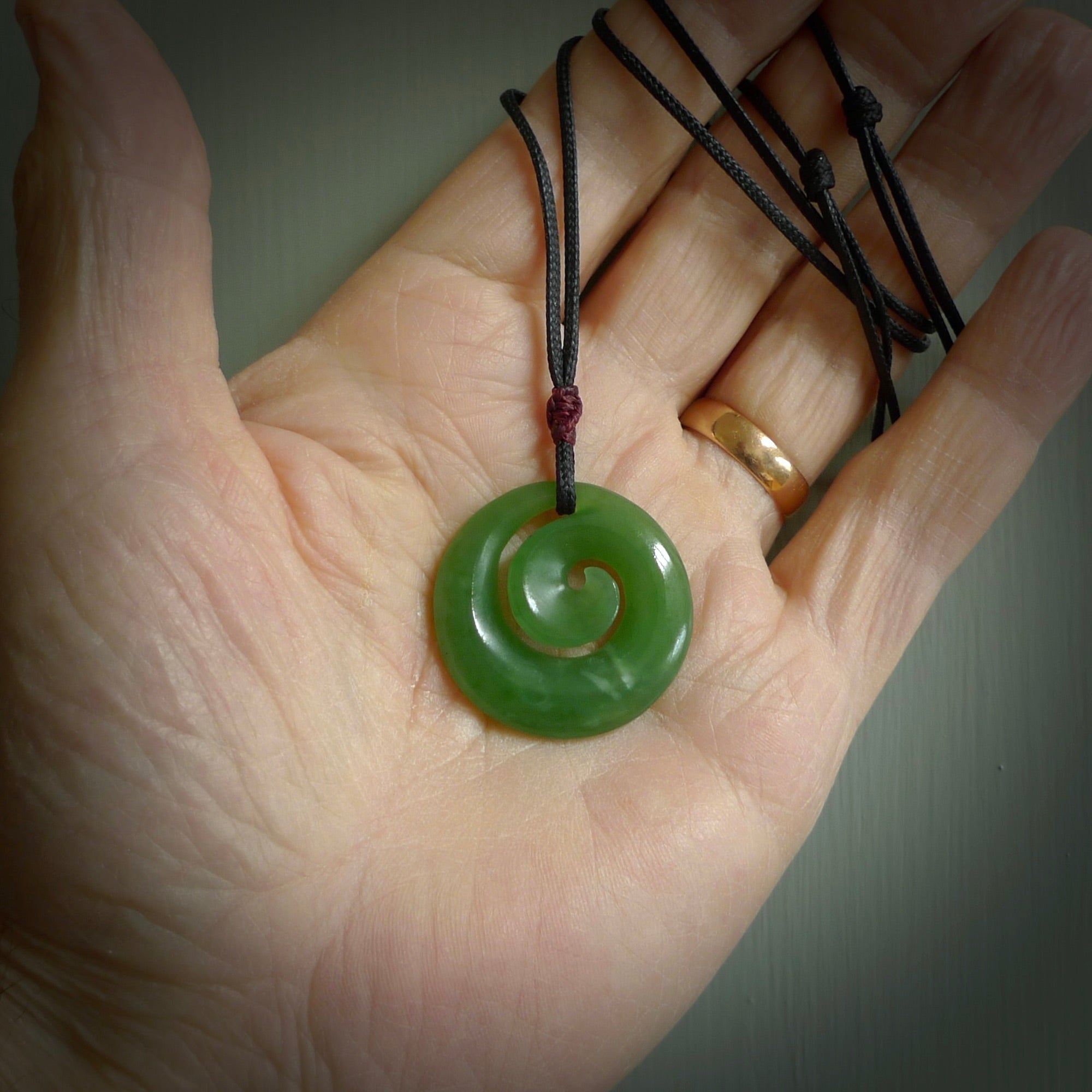 Hand carved New Zealand Inanga jade koru pendant. Carved for NZ Pacific by Ross Crump. Jade jewelry for sale online exclusively with NZ Pacific.