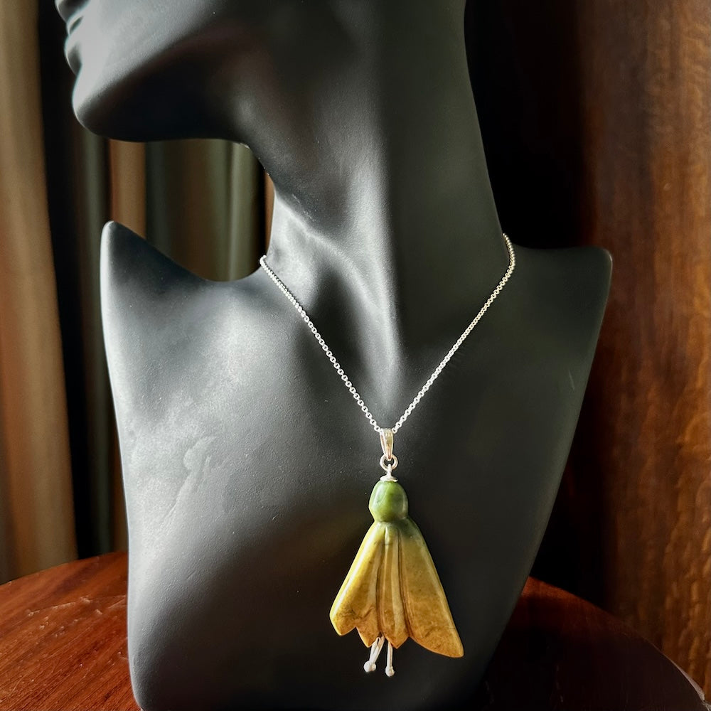 This kowhai flower drop pendant is beautifully hand made with gorgeous flair. It is fashionable and perfect for a women with style. Hand carved from a gorgeous piece of New Zealand Flower jade and sterling silver - this is an elegant and beautiful piece of art to wear.