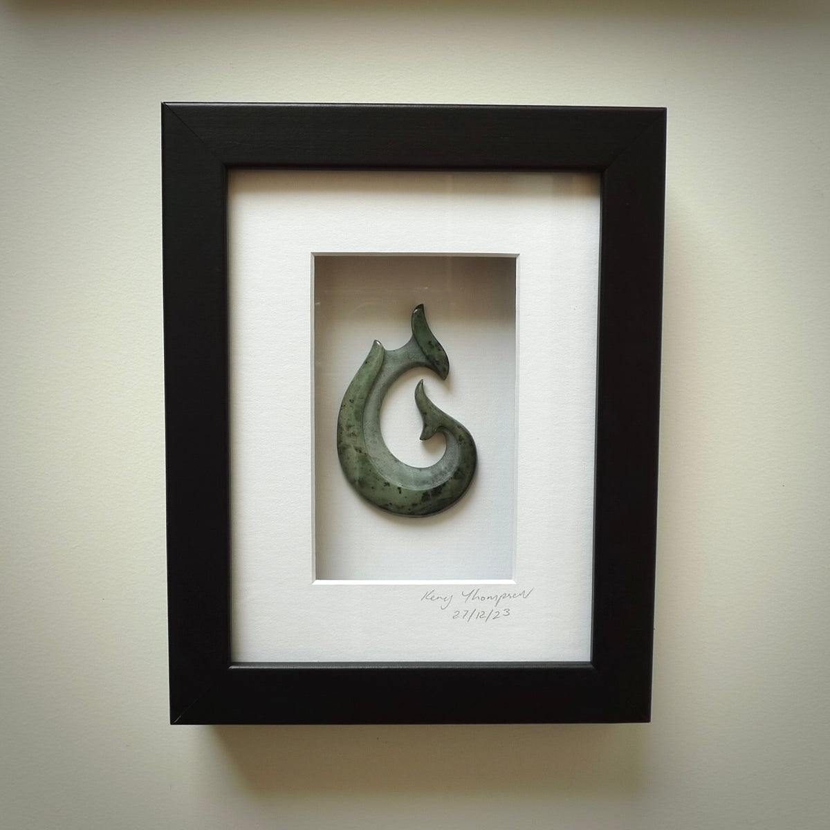 A hand carved large New Zealand Jade Hook, Matau, necklace that has been framed and signed by artist Kerry Thompson. A large sized hand made hook necklace by New Zealand artist Kerry Thompson. One off framed work of art to wear. Delivered with Express Courier.