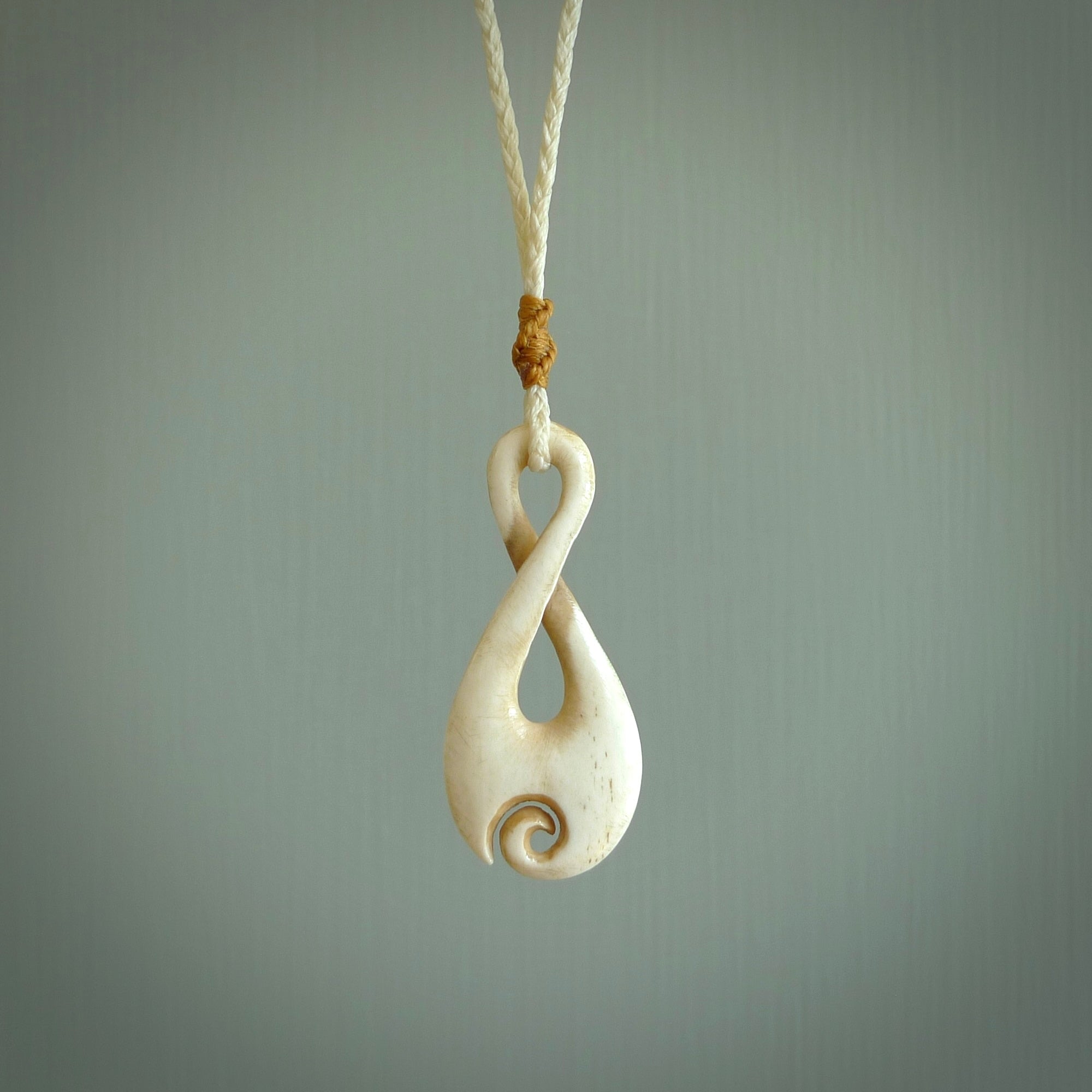 Hand carved Single twist pendant with a little koru carved into the bottom. This pendant is carved from a lovely cream coloured bone. The artist is Yuri Terenyi. Bone art to wear by NZ Pacific.