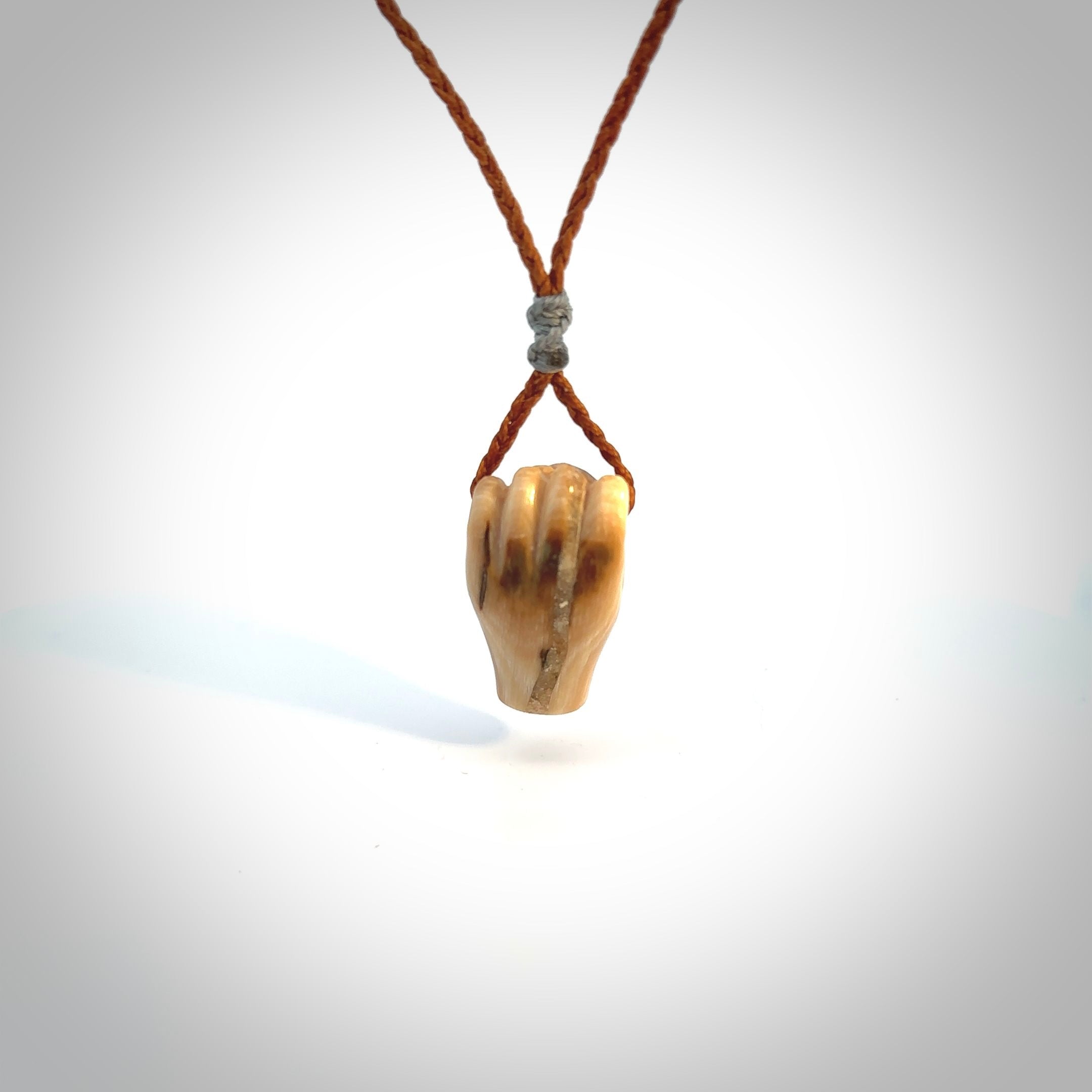 Hand carved pendant symbolising strength and hope - Shown worn. Carved by NZ Pacific from ancient woolly mammoth tusk. Unique jewellery for sale online.