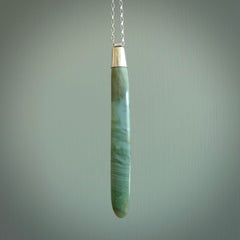 This picture shows a hand carved Inanga Pounamu, jade drop pendant with sterling silver cap and chain. The jade is a very dark green with a shimmer of light blue tones in the stone. It is suspended from a sterling silver clasp and we supply a sterling silver chain. Delivery is free worldwide.