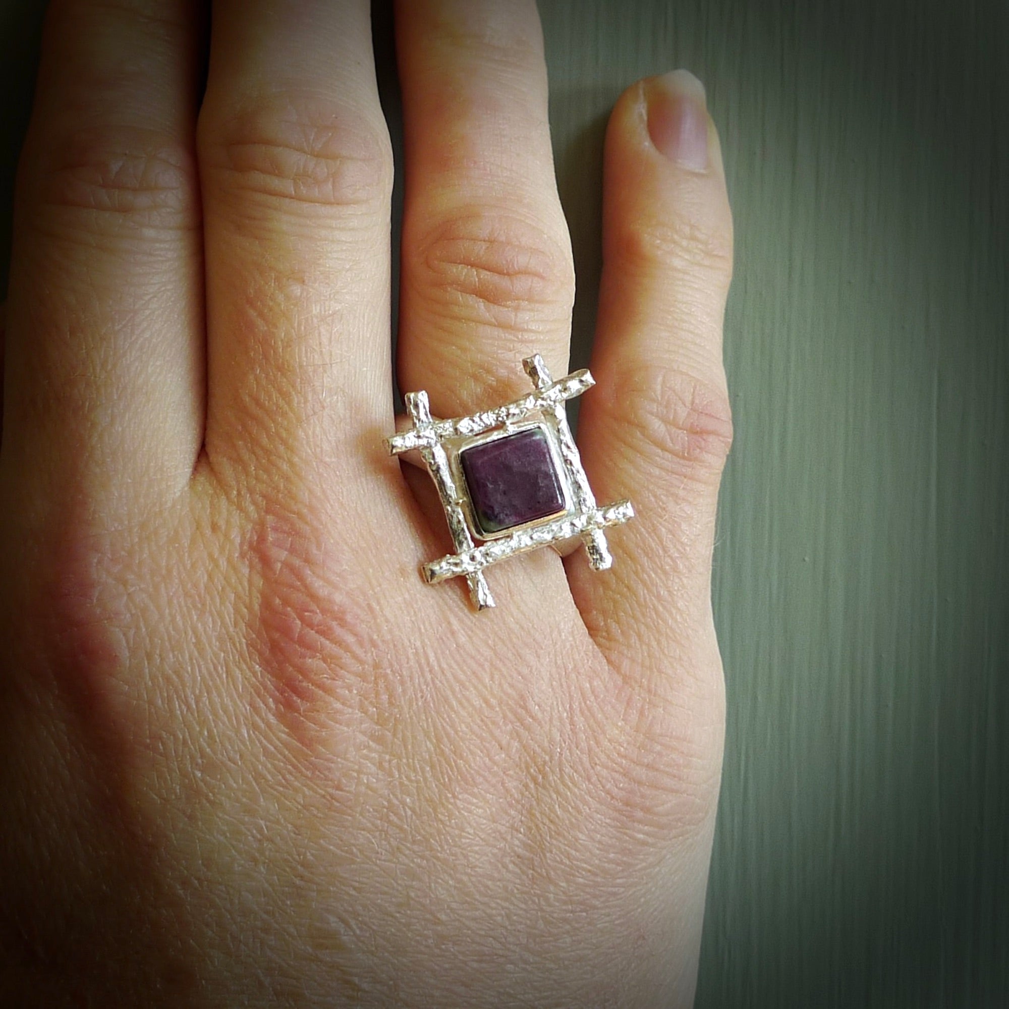 This is a handcrafted New Zealand Ruby, stone with sterling silver ring. This is a solid little work of art. We ship this worldwide for free and are happy to answer any questions that you may have about these or other products on our website. Hand made by Ana Krakosky and delivered in a woven kete pouch.