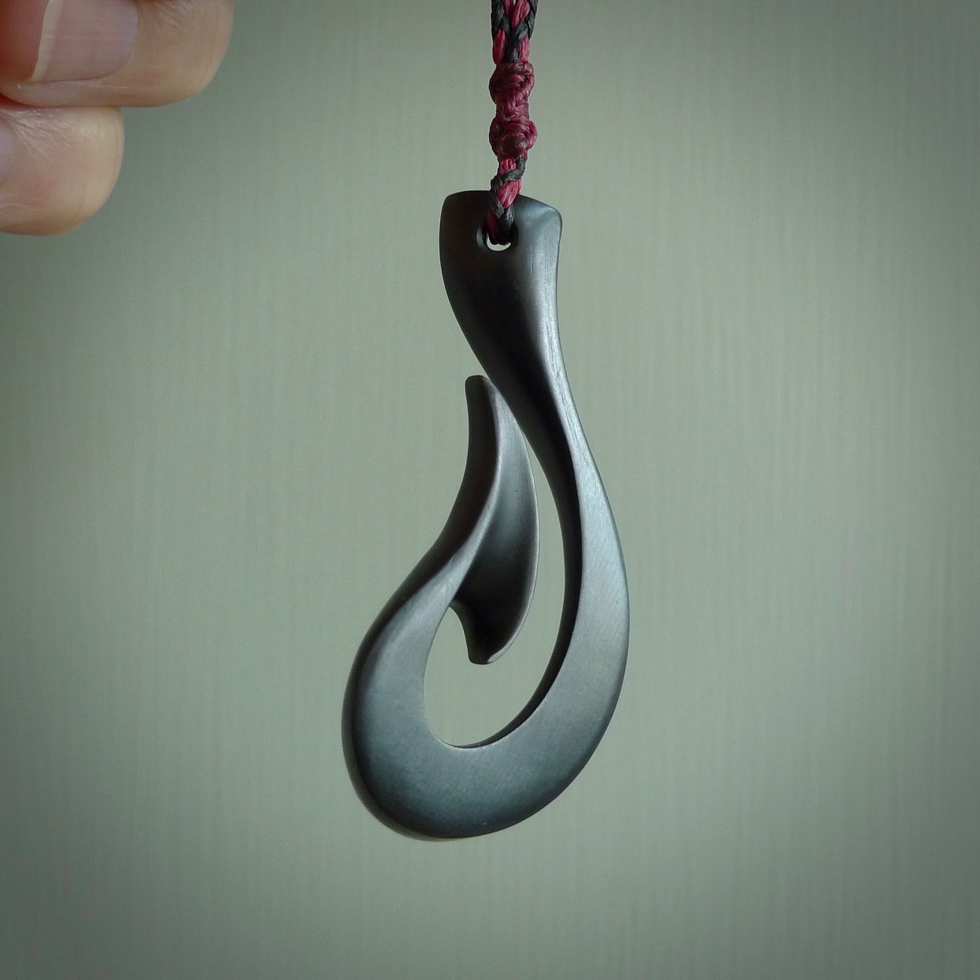 A hand carved large Black Jade Hook, Matau, necklace. The cord is a black colour and is a fixed length. A large sized hand made hook necklace by New Zealand artist Kerry Thompson. One off work of art to wear.