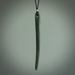 This picture shows a hand carved Pounamu jade beak drop pendant with adjustable cord. The jade is a very dark green with shimmering blue tones in the stone. It is suspended from a adjustable cord. Delivery is free worldwide.