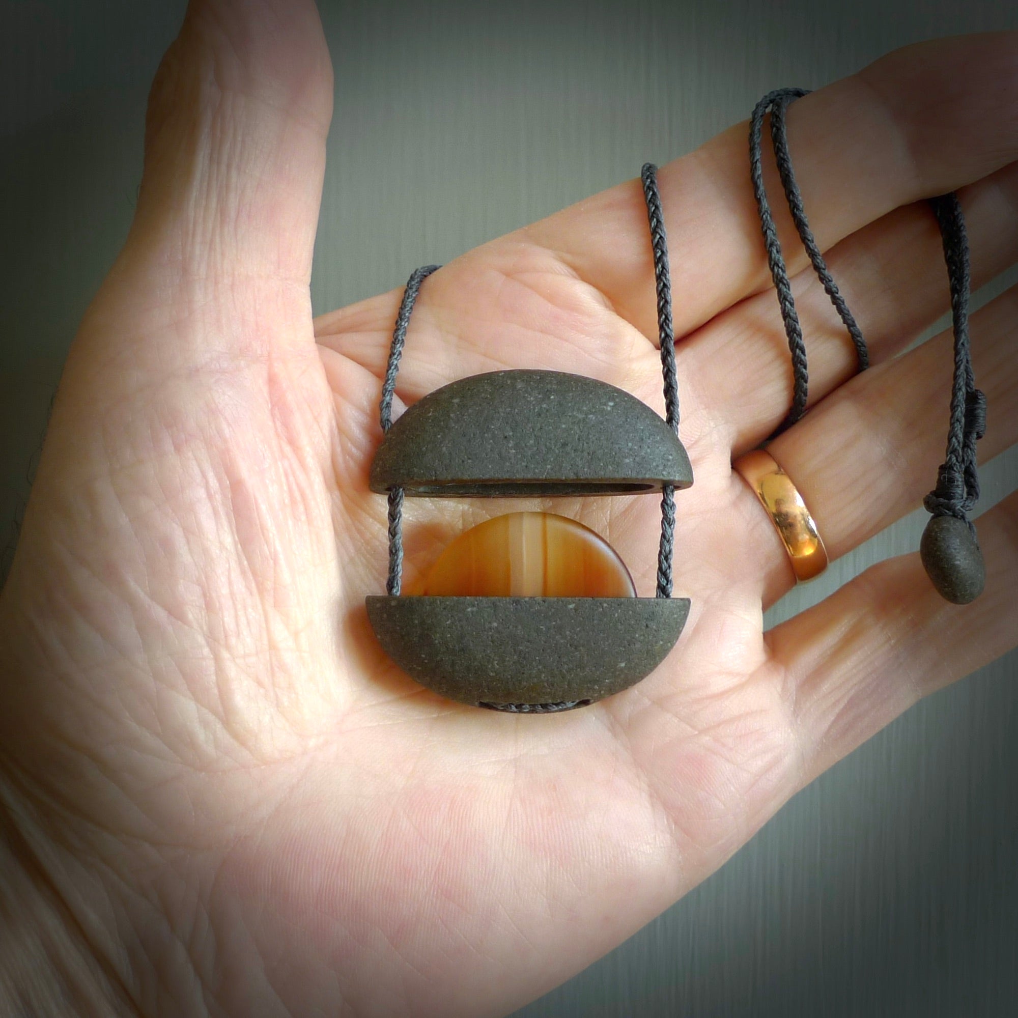 Greywacke stone pendant with Carnelian Stone insert. Hand carved by Rhys Hall for NZ Pacific. Handmade contemporary jewellery for sale online.