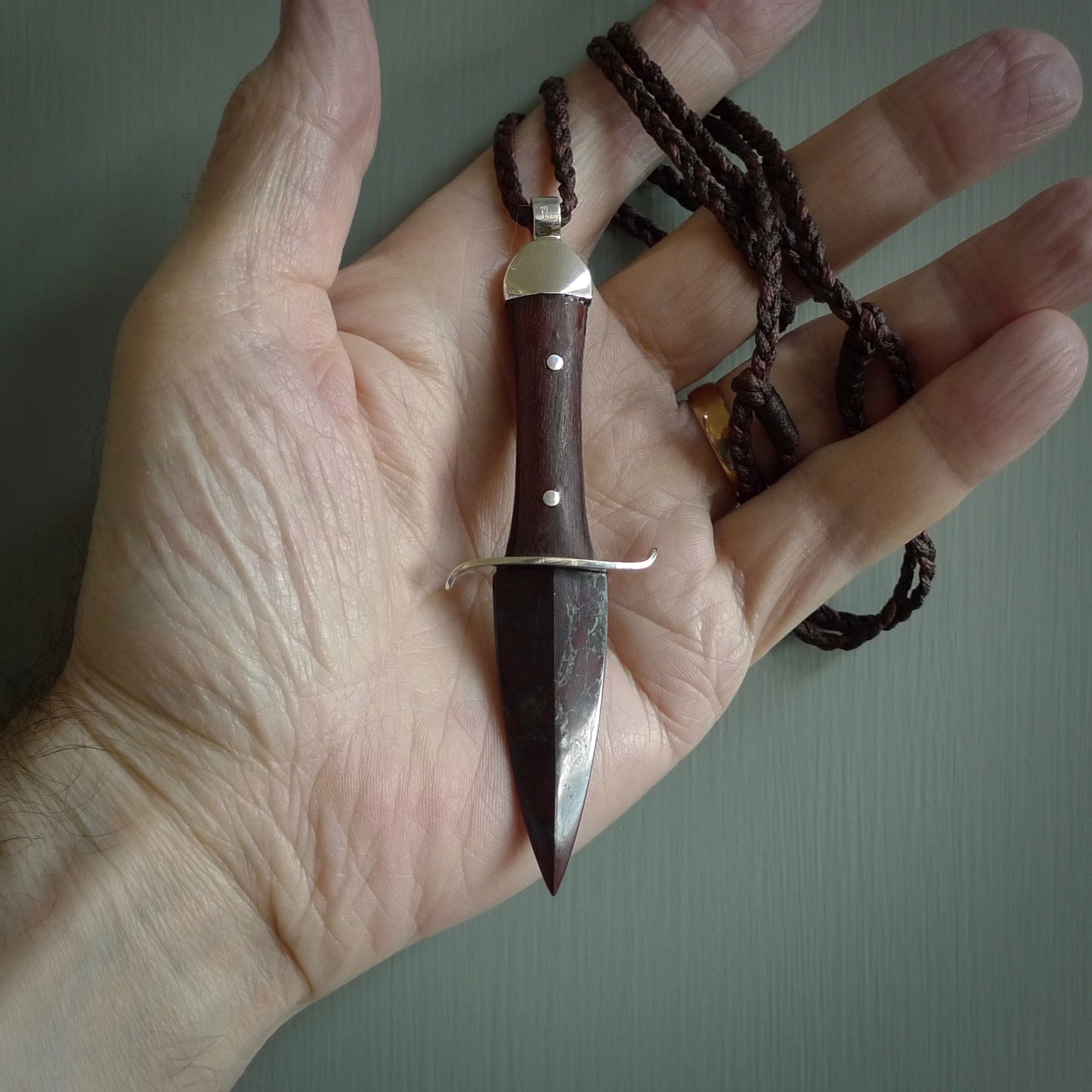 A striking hand carved knife pendant. These are carved with a Red Jasper Stone head and a hardwood handle. The cords are hand plaited in our waxed polyester which is robust, strong and durable. We ship these worldwide with express courier.