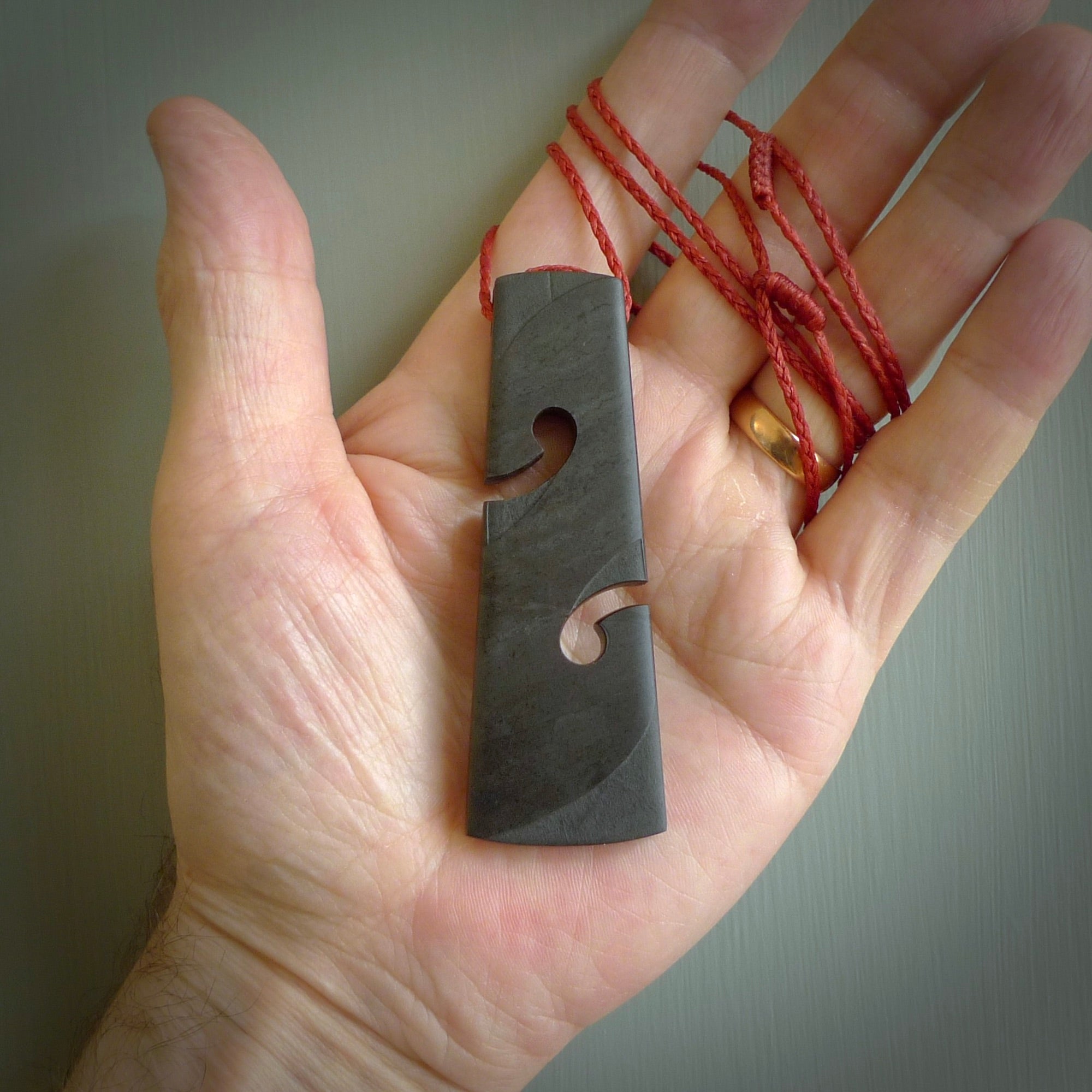 Hand carved New Zealand Argillite Toki with double koru by Rueben Tipene. We provide this large toki on an adjustable cord and ship to you in a kete pouch with Express Courier. This is a one off pendant that once sold will be removed from our site.