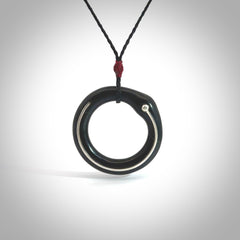 This picture shows a hand carved black jade circle pendant with sterling silver inlay. It is suspended from an adjustable Black cord. Delivery is free worldwide.