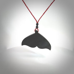 Hand carved New Zealand Argillite Stone whale tail pendant by Rueben Tipene. Hand made art to wear for lovers of the ocean. Delivered with express courier and delivered to you on an adjustable cord.