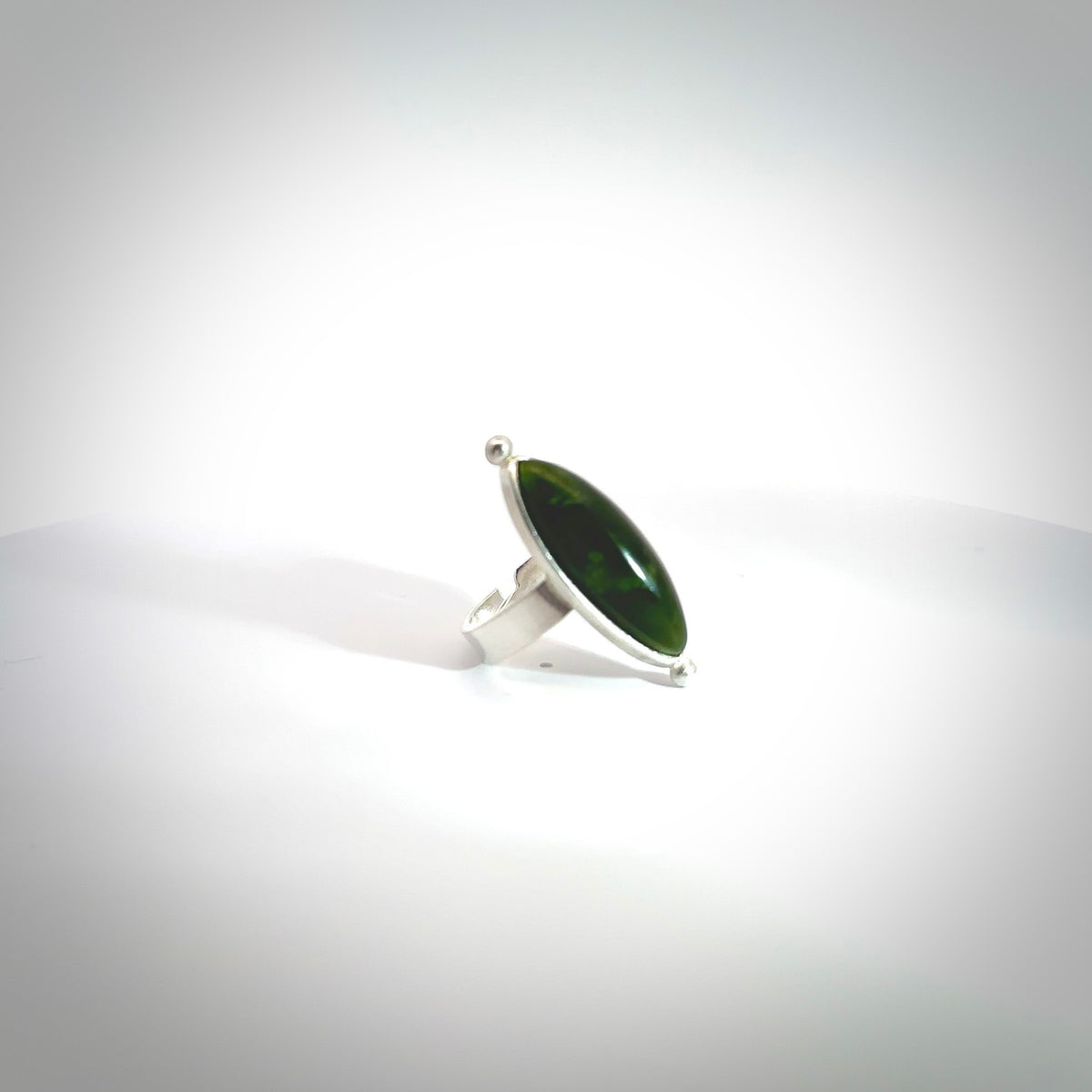 This is a handcrafted New Zealand Pounamu, Jade and sterling silver ring. This is a solid little work of art. We ship this worldwide for free and are happy to answer any questions that you may have about these or other products on our website. Hand made by Ana Krakosky. Contemporary art to wear, one only ring. Delivered with Express Courier and packaged in a woven kete pouch.