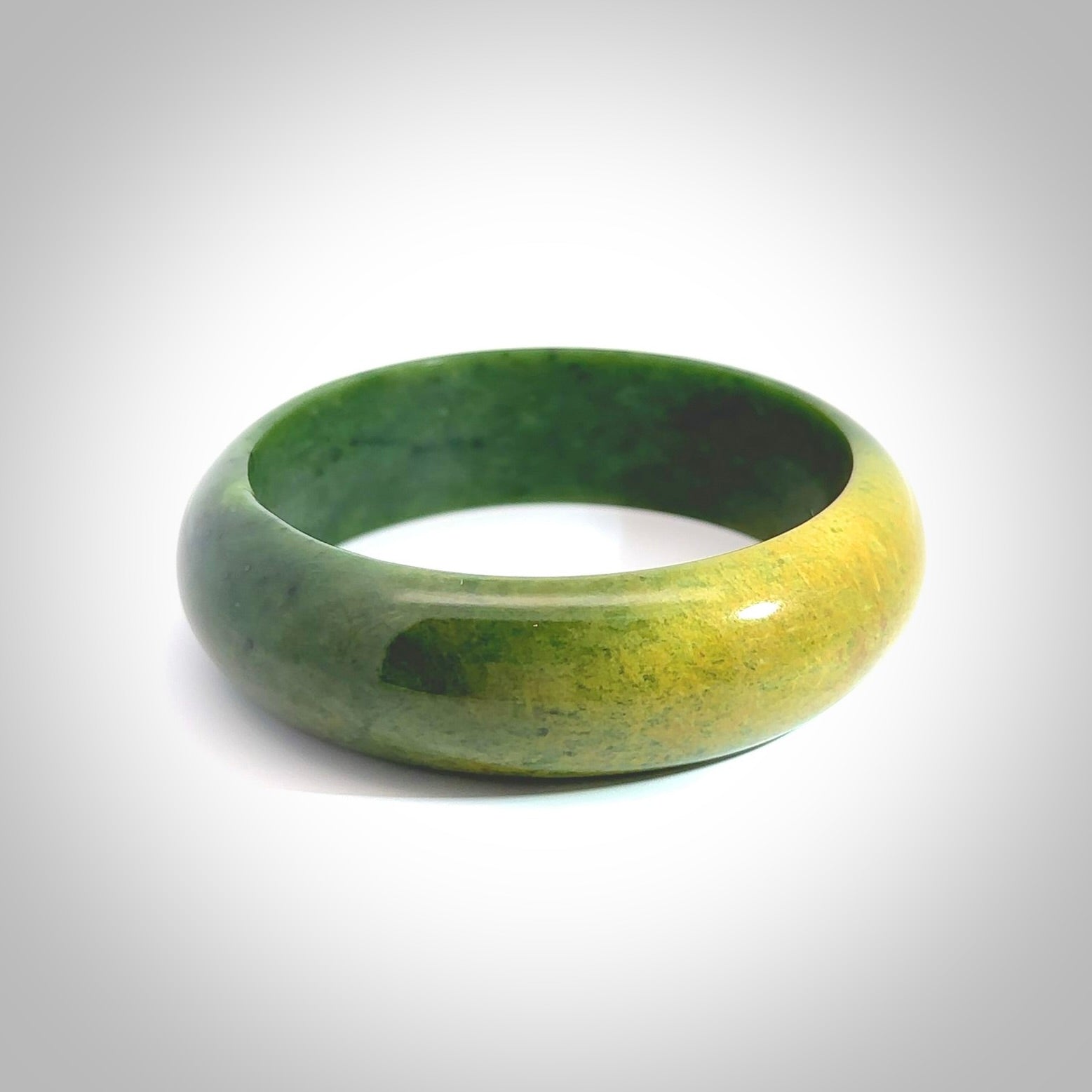 Hand carved jade bangle. Carved from green New Zealand jade. This is a solid jade bangle carved from a single piece of jade. It is polished to a soft shine. the jade is otherwise untreated and completely natural.