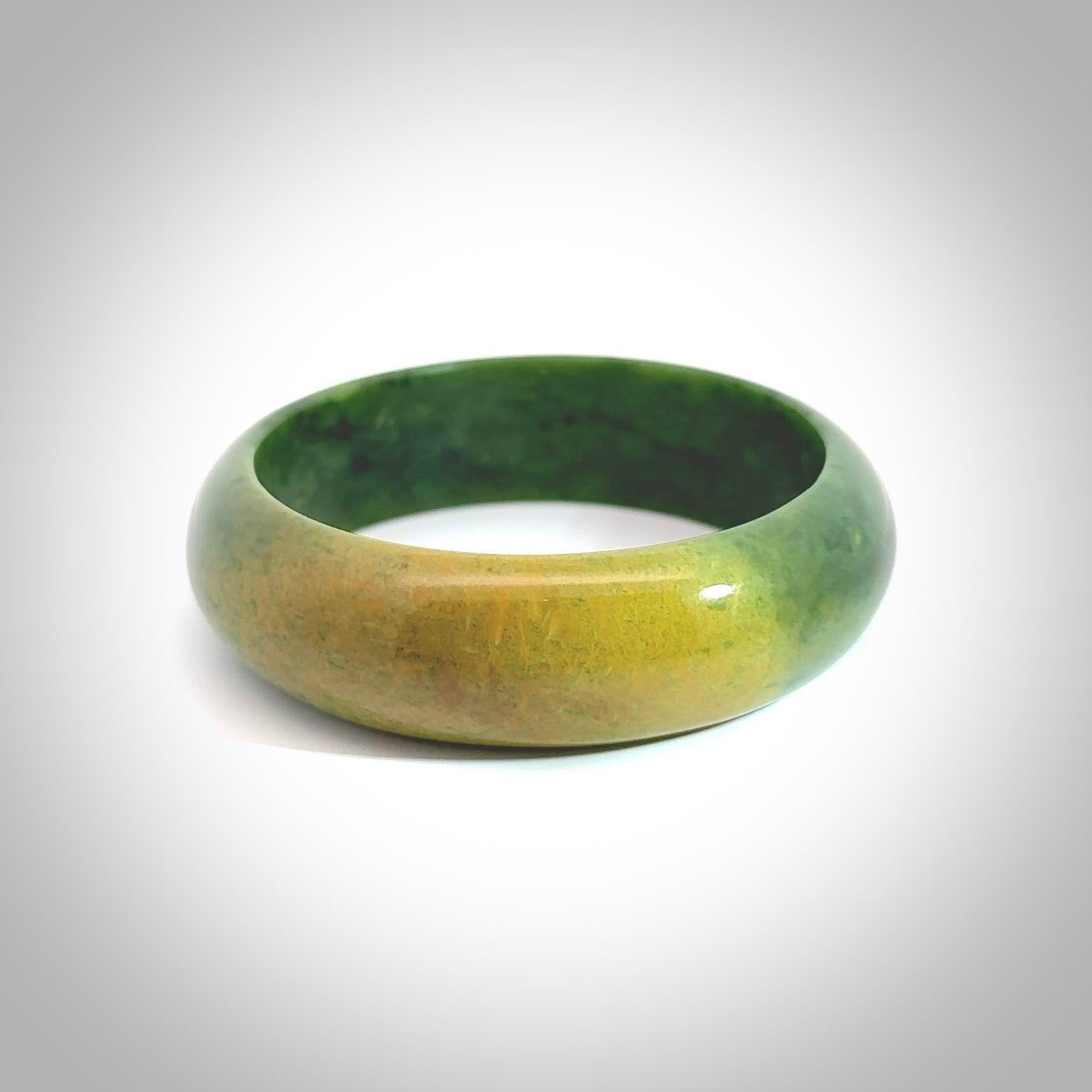 Hand carved jade bangle. Carved from green New Zealand jade. This is a solid jade bangle carved from a single piece of jade. It is polished to a soft shine. the jade is otherwise untreated and completely natural.