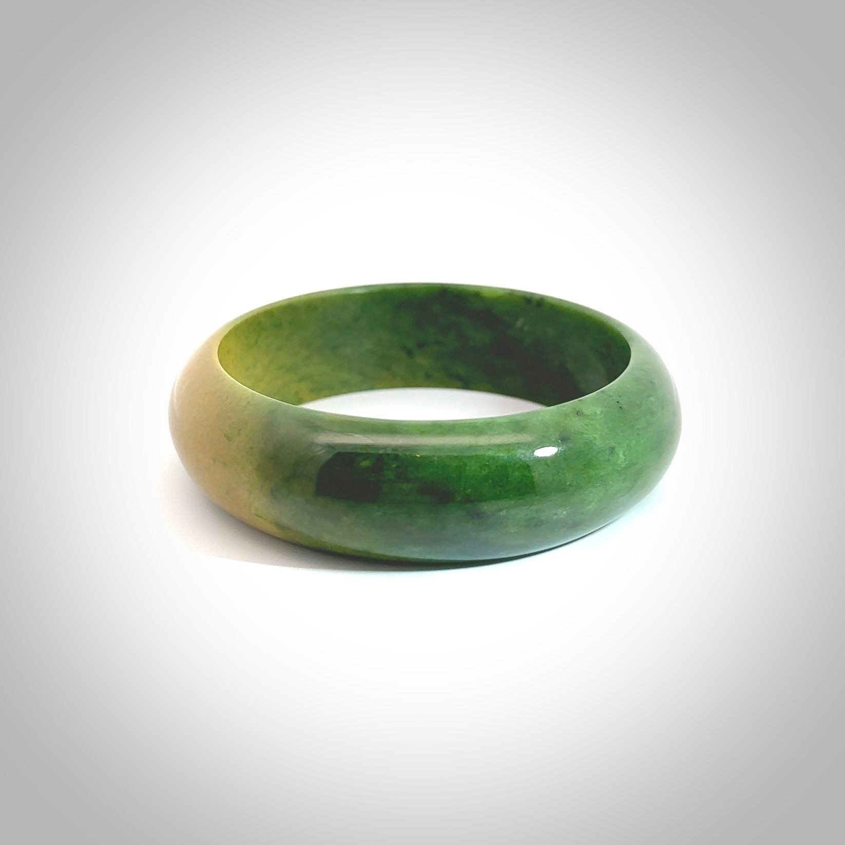 Hand carved jade bangle. Carved from green New Zealand jade. This is a solid jade bangle carved from a single piece of jade. It is polished to a soft shine. the jade is otherwise untreated and completely natural.