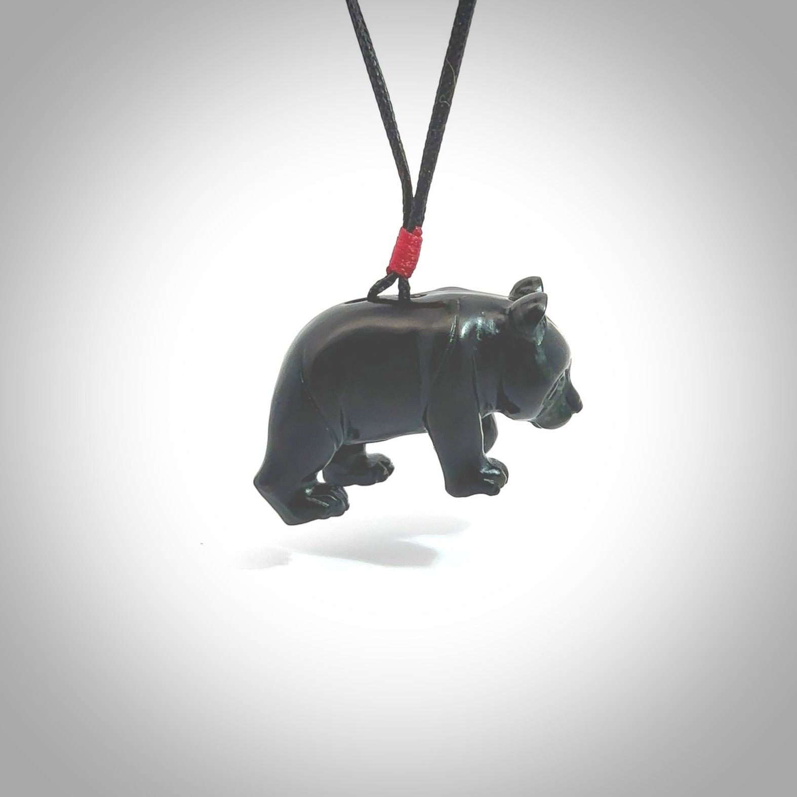 This picture shows a pendant that we designed in black jade. It is a little black bear that has a walking stance and is carved in detail. A really attractive and eye-catching piece of handmade jewellery. The cord is hand plaited braid in black and pale honey and the length can be adjusted.